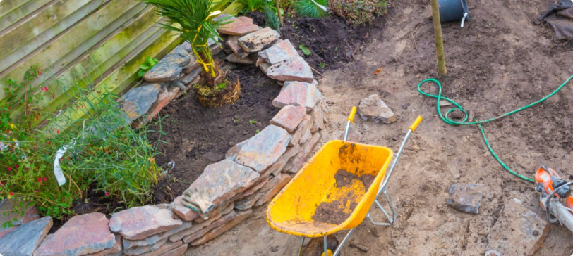 Rock Creations and Earthworks Garden in a Small Backyard with Gardening Equipment